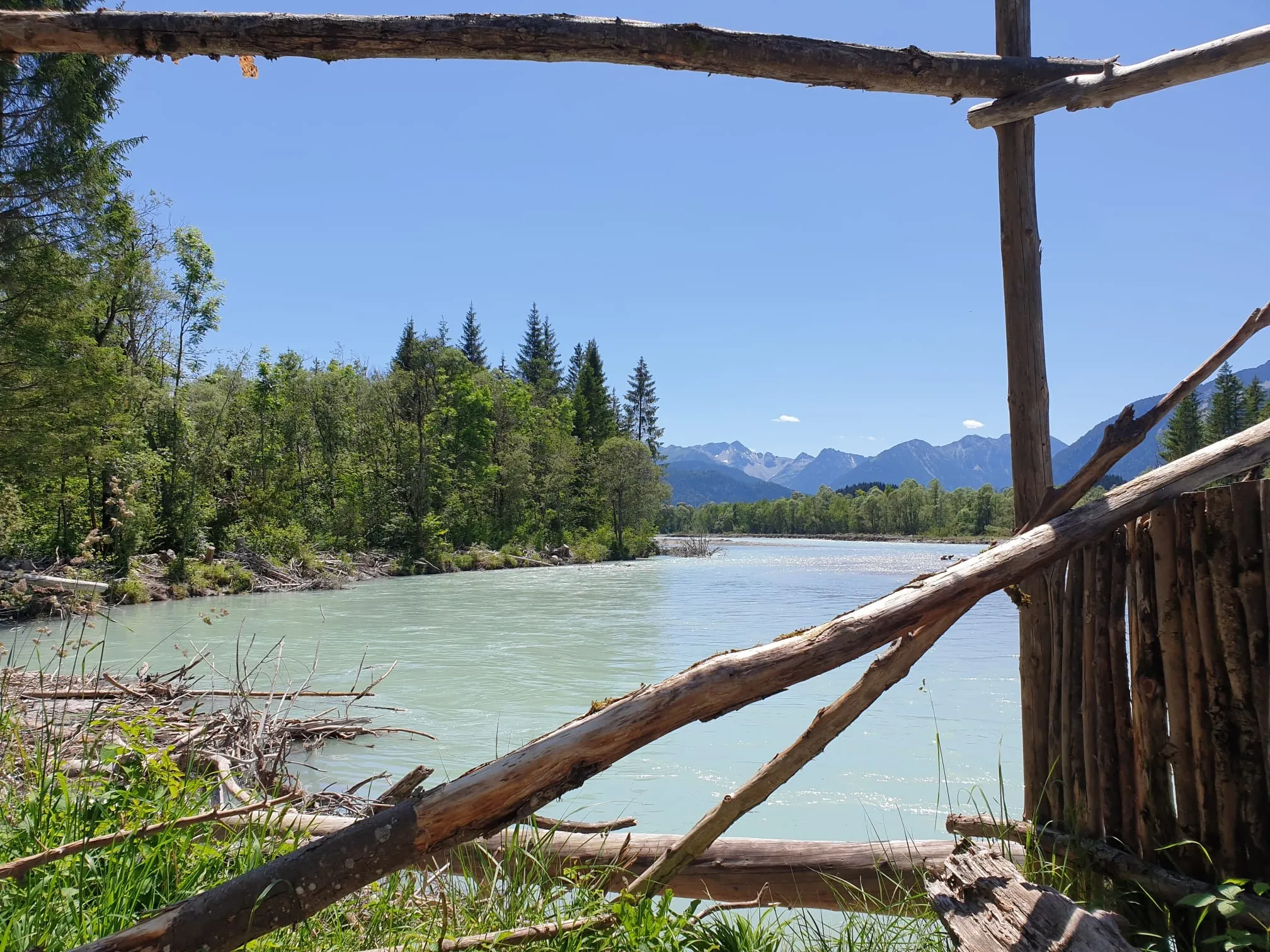 Ein klarer Fluss im Allgäu mit Bergen im Hintergrund